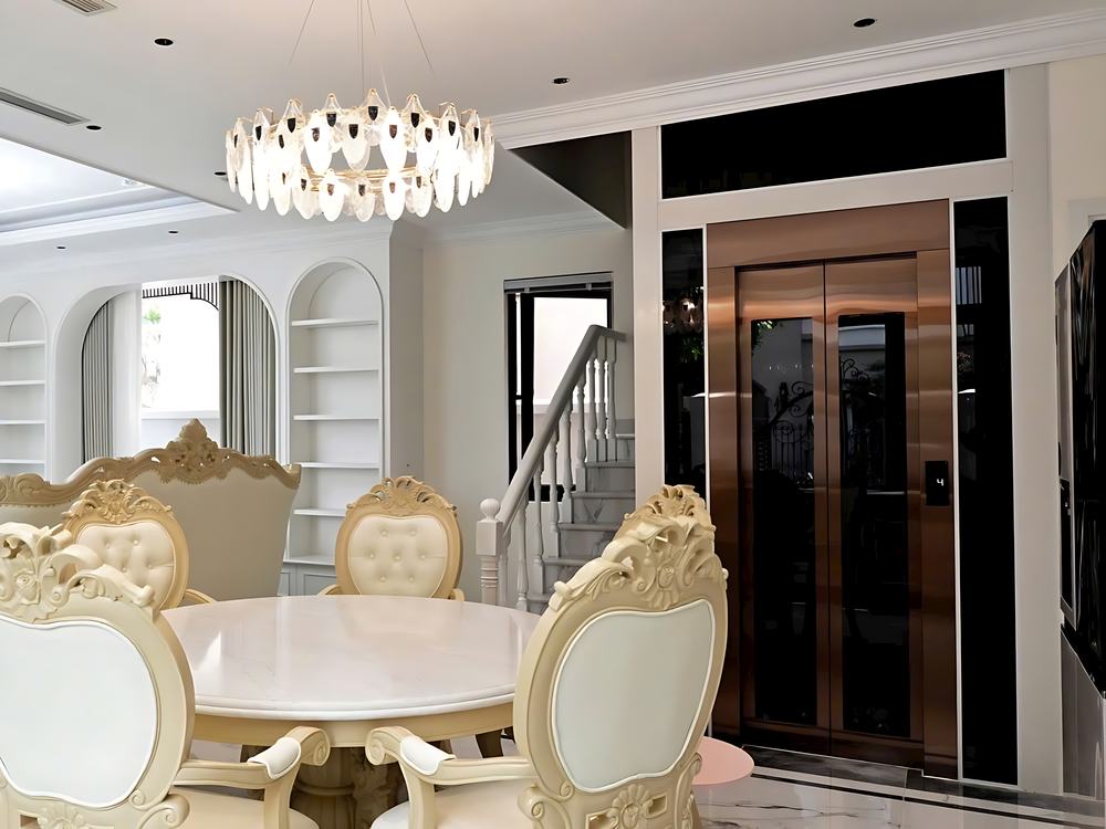 Thang máy gia đình cửa inox đồng trong phòng khách biệt thự tân cổ điển